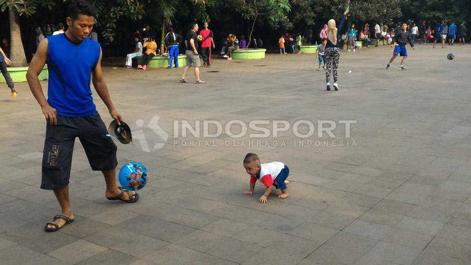 Seorang ayah menemani anaknya bermain sepakbola di CFD Bekasi.